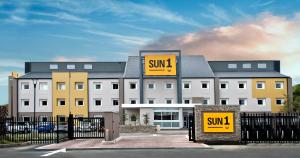 a large white building with yellow signs on it at SUN1 ALBERTON in Johannesburg