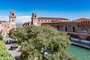 un edificio con torre dell'orologio accanto a un fiume di Casetta Biennale Arsenale VeniseJeTaime a Venezia