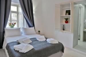 um quarto com uma cama com duas toalhas em Douskos Port House em Hydra