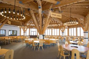 a dining hall with tables and chairs and chandeliers at Berghaus Nagens-- Nur mit der Gondelbahn Erreichbar in Flims