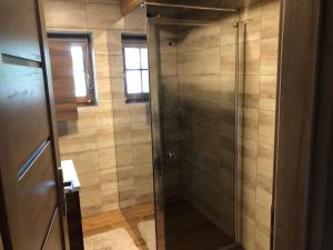 a shower with a glass door in a bathroom at Chata Eden in Hrabušice