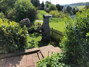 einen Garten mit einem Steinvogelbad im Gras in der Unterkunft Ferienwohnung Anita in Michelstadt