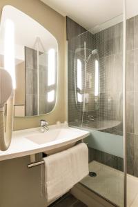 a bathroom with a shower, sink, and mirror at ibis Paris Gare du Nord Château Landon 10ème in Paris