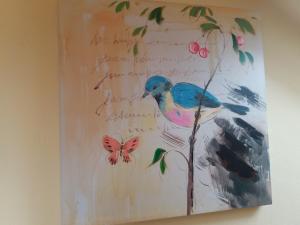 a painting of a bird on a tree with a butterfly at Apartment Felix in Split