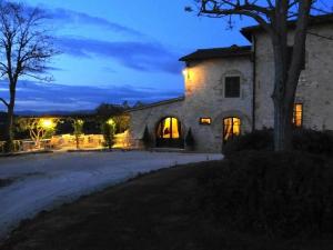 コッレ・ディ・ヴァル・デルザにあるTaverna di Bibbianoの夜の灯り付きの大きな石造りの家