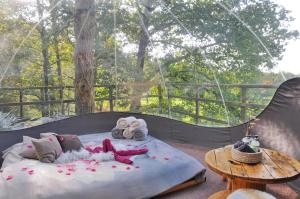 łóżko z ręcznikami i pluszowymi zwierzętami siedzącymi na nim w obiekcie Sphair perchée w mieście Fisenne