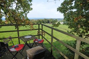 een tafel en stoelen op een terras met uitzicht op een veld bij Sphair perchée in Fisenne