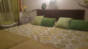 a bedroom with a bed with green and yellow pillows at Fonda Felip in Port de la Selva