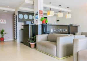 a waiting room with a couch and a reception at Albizia Beach Hotel in Varna City