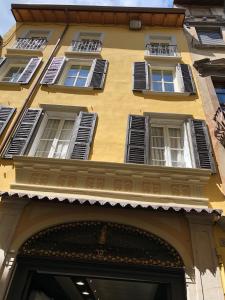 a yellow building with white windows and a doorway at Casa Collini Salò in Salò