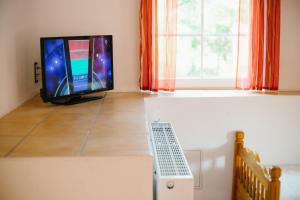 a living room with a tv and a window at Zum Eichenfrieden in Rade