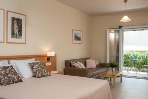 sypialnia z łóżkiem i kanapą w obiekcie Hotel Estia w mieście Finikounda