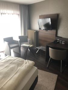 Mossautalにあるhotel zentlindeのベッド、テーブル、椅子が備わるホテルルームです。