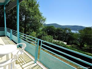 a balcony with a table and chairs and a view of the water at Les Fées du lac *** in Nages +9 photos