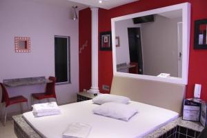 a salon with a mirror and a white table and chairs at Motel Emoções de Guarulhos in Guarulhos