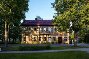 ein großes Gebäude mit einem Balkon davor in der Unterkunft Hotel Benevilla in Alūksne