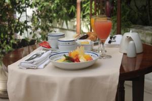 a table with a bowl of fruit and a drink at Hotel Club Frances in Buenos Aires