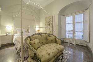 sypialnia z łóżkiem z baldachimem i krzesłem w obiekcie ApartaSuites Alberca Deluxe w Kordobie