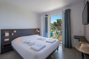 Postel nebo postele na pokoji v ubytování Hôtel-Club du Domaine d'Aiguebelle, USSIM Vacances