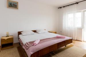 a bedroom with a large bed with pink pillows at Apartments G&M in Vodice