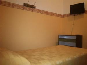 a bedroom with a bed and a tv on the wall at Hotel Dorico in Ancona