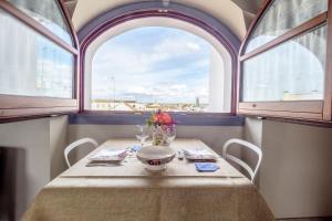 a table with a vase of flowers on a table in a window at ApartaSuites Alberca Deluxe in Córdoba