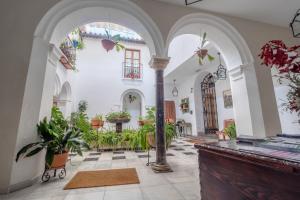 an indoor courtyard with plants in a building at ApartaSuites Alberca Deluxe in Córdoba