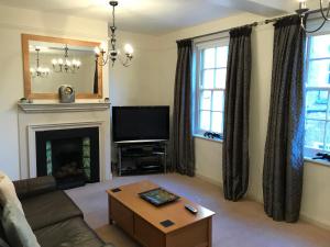 a living room with a couch and a tv and a fireplace at 7 Precentor's Court in York