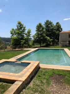 a swimming pool in a yard with a stone wall at Helen's Stone House in Siviri