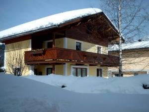ein schneebedecktes Haus mit einem schneebedeckten Dach in der Unterkunft Ferienwohnung Huber in Söll