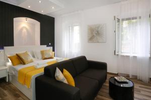 a bedroom with a bed and a couch in it at Studio Apartman Fictilis in Split