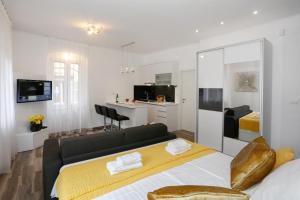 a bedroom with a bed and a living room at Studio Apartman Fictilis in Split