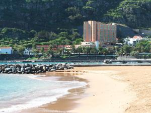 a view of a beach with a hotel in the background at Dom Pedro Madeira in Machico