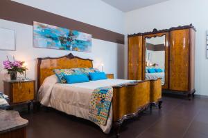 1 dormitorio con 1 cama grande y espejo grande en Al Castello, en Marsala