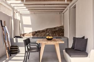 a dining room with a wooden table and chairs at Boho Private Luxury Suites in Mikonos