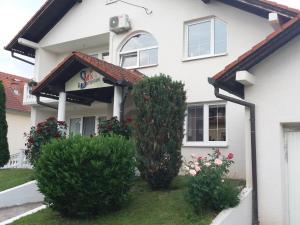 Biały dom z dwoma krzakami przed nim w obiekcie Smx Apartement w mieście Prelog