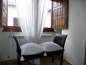 a chair with two pillows in front of a window at Casa Granero in Rascafría