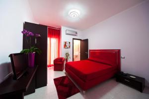 a bedroom with a red bed and a red couch at Hotel Glamour in Qualiano