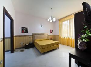 1 dormitorio con 1 cama y TV en Hotel Glamour, en Qualiano