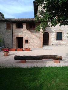 una panca di legno seduta di fronte a un edificio di Agriturismo"Il Sagrato di Assisi" appartamenti,camere ad Assisi