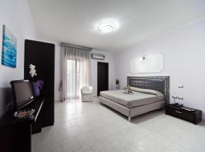 1 dormitorio con 1 cama y TV. en Hotel Glamour, en Qualiano