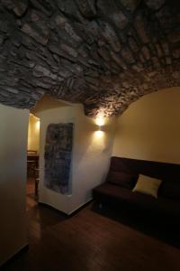 Rocchetta di VaraにあるAgriturismo Giuminの石造りの天井のリビングルーム(ソファ付)