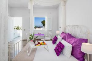 a living room with a white couch and purple pillows at Sol Mare Salis in Kamari