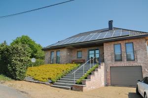 una casa de ladrillo con paneles solares en el techo en Nid des Amis, en Somme-Leuze