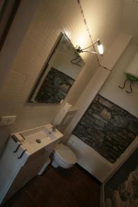a bathroom with a sink and a toilet and a mirror at Agriturismo Giumin in Rocchetta di Vara