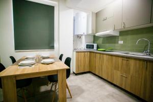 a kitchen with a wooden table and a blackboard at Lira Holiday Apartments in Eforie Nord