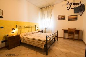 a bedroom with a bed and a table and a desk at B&b Il grappolo Foresteria Lombarda in Sirmione