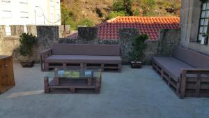 a patio with benches and a table and a building at Vilavella alojamiento de época in Redondela
