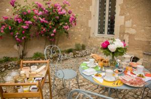 una mesa con un plato de comida y flores en ella en LE PRIEURÉ, en Noyers-sur-Serein