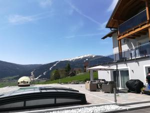 a building with a glass roof with mountains in the background at Sonnseite in Sankt Margarethen im Lungau